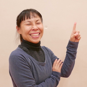 コメント用写真：片岡まり子先生が笑顔で人差し指をたてている