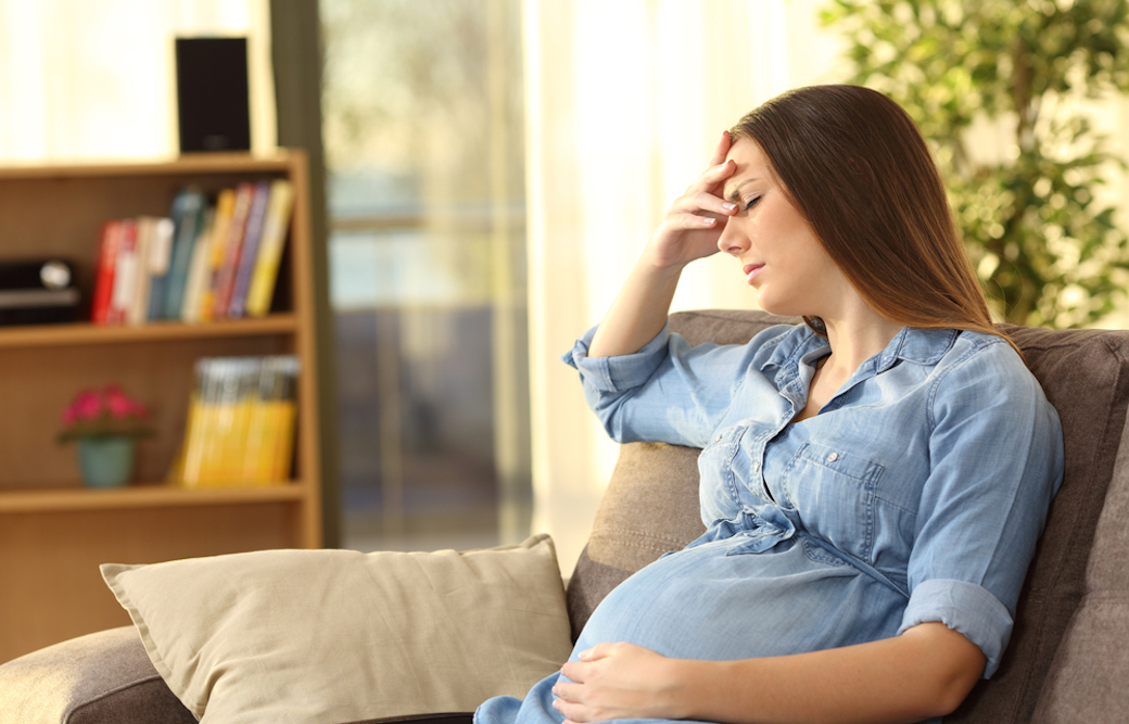 大きなお腹を抱えながら一人で悩む妊婦