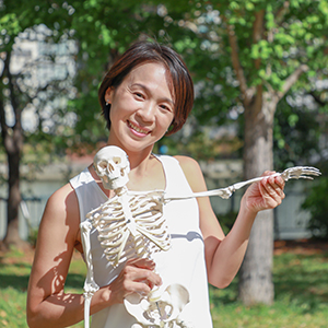 Miwa先生が骨模型を持って微笑んでいる