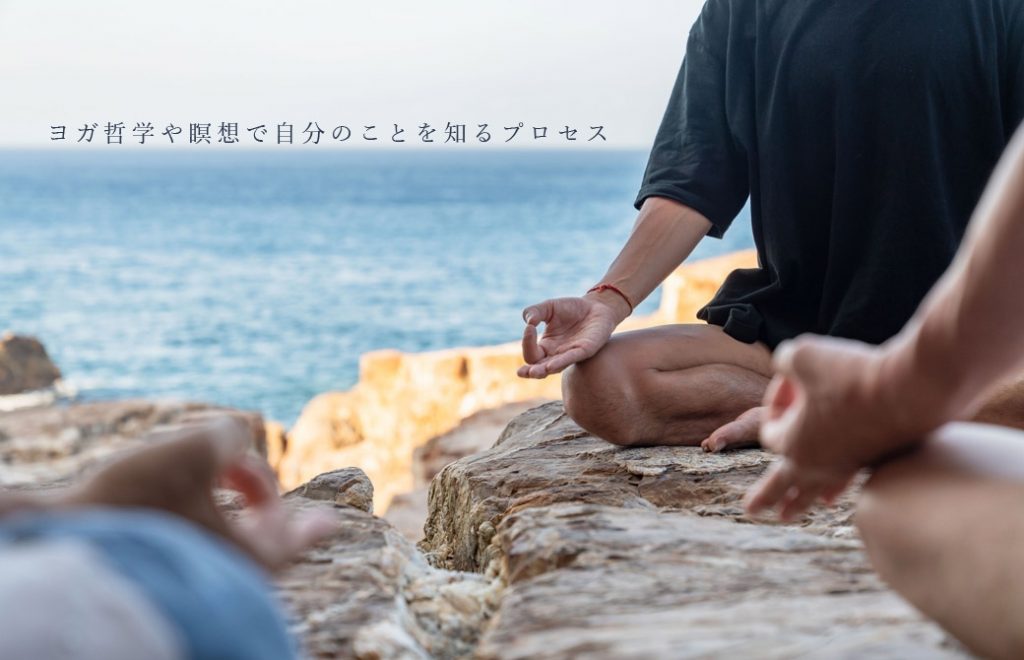 海岸の岩の上で胡坐を組んで、印を結んでいる3人の男性