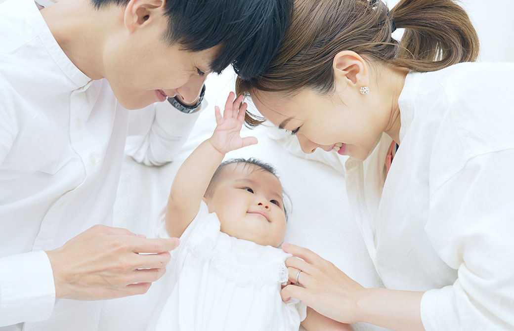 赤ちゃんに向かって微笑んでいる夫婦